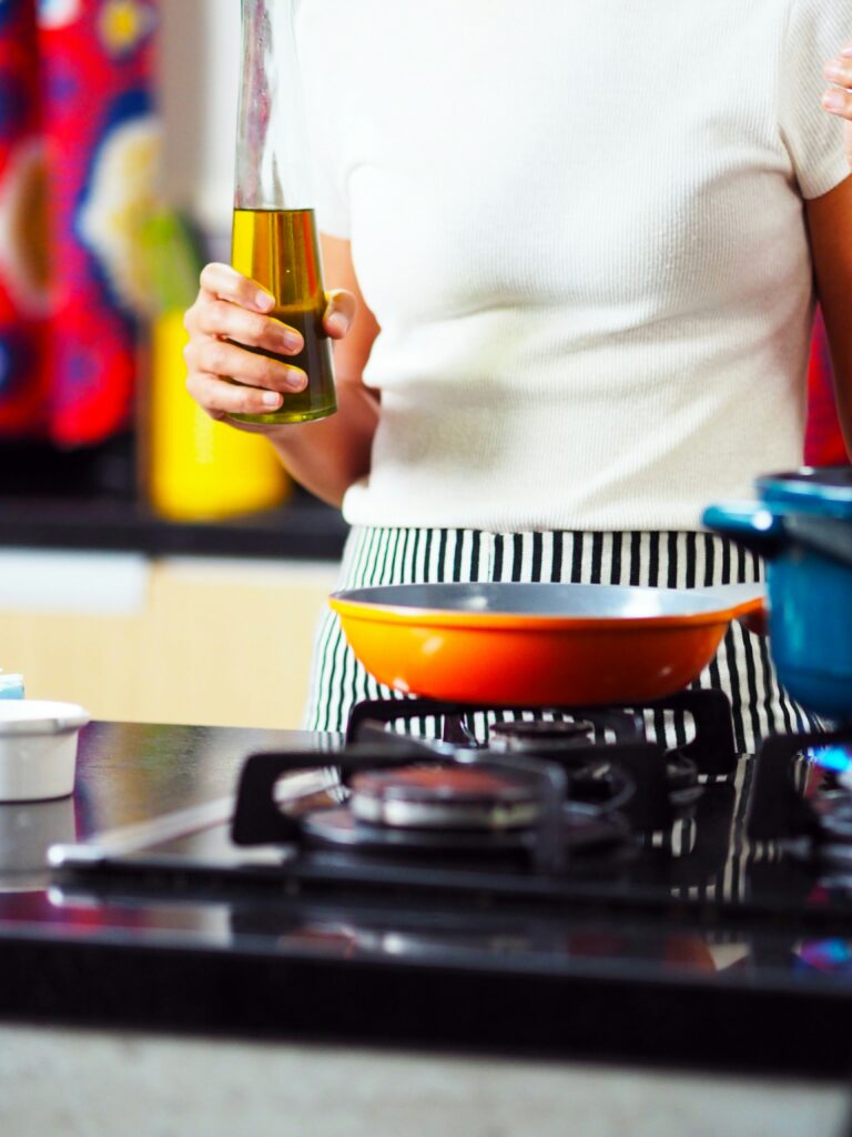 Understanding the Best Cooking Oils to Use with bottles of cooking oil, fresh vegetables, and ingredients prepared for healthy meal cooking.